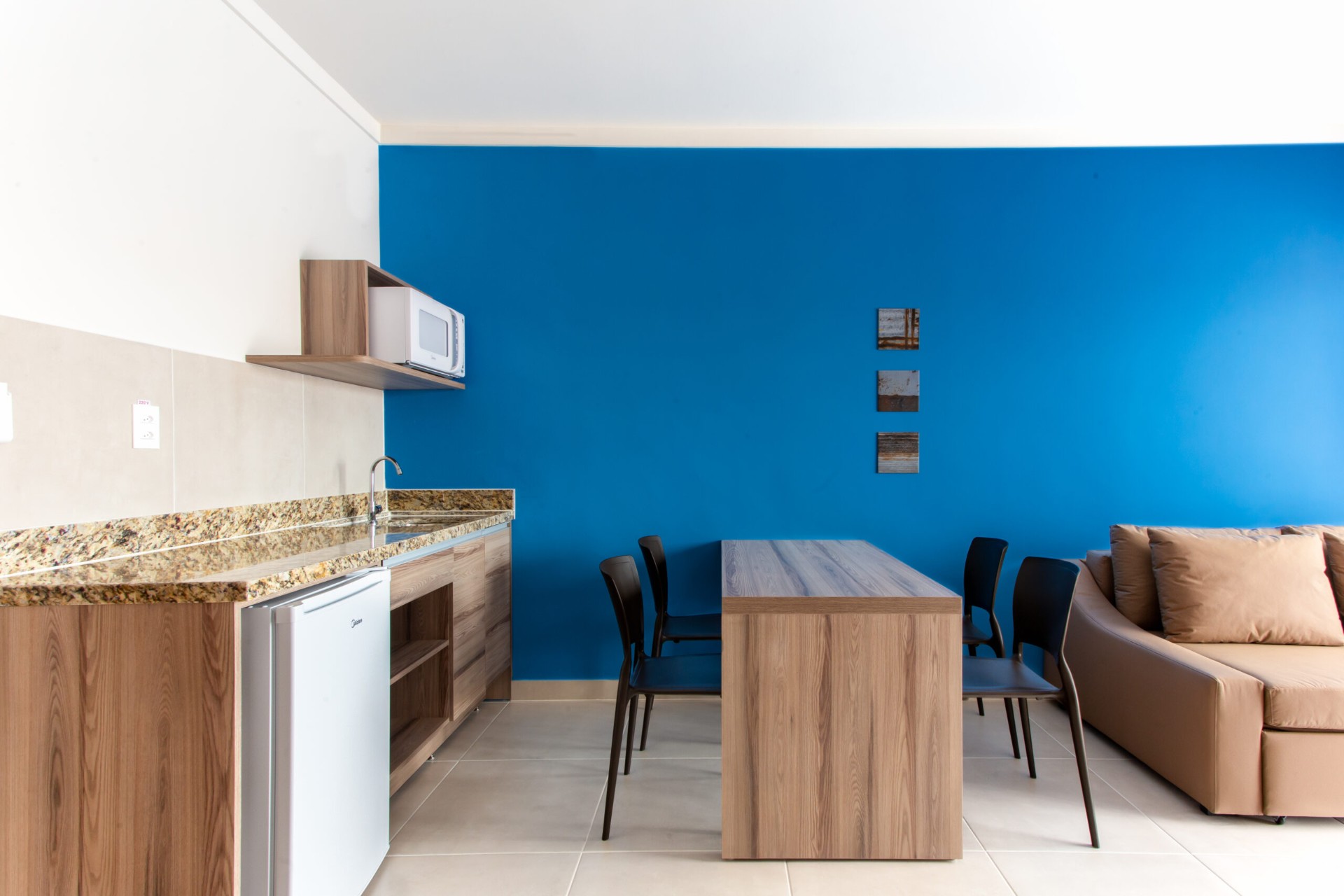 Minicozinha com frigobar, micro-ondas e mesa de jantar